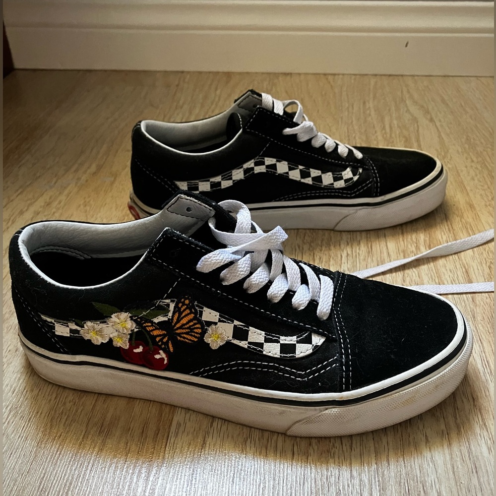 Black and white old skool vans with checkered detail on the side
